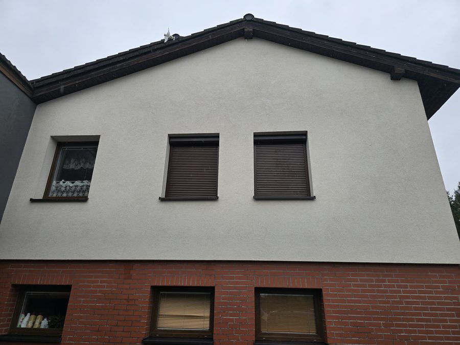 Štít domu s omítkou a cihlovým obkladem bez šmouh, rovnoměrná světlá plocha