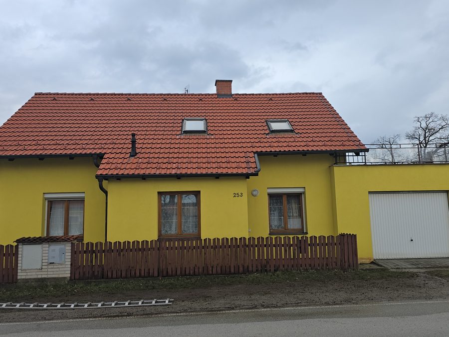 Střecha rodinného domu z pálené tašky v přirozené červené barvě bez povlaku a stružek